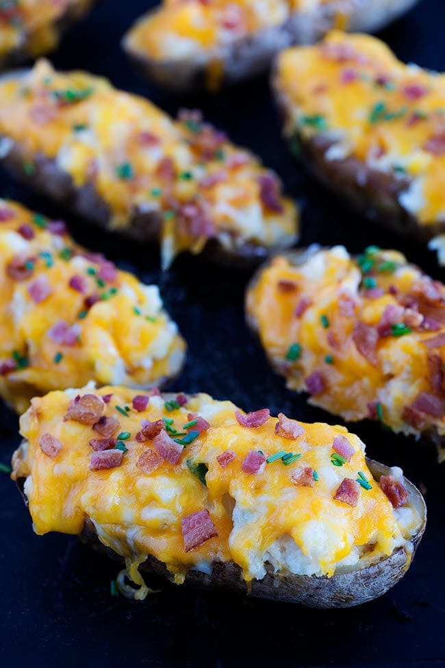 Twice Baked Potatoes-Salty and crisp baked potato shells stuffed with light and fluffy mashed potatoes, cheese, and bacon. These cheesy potatoes are a family favorite side dish and go great with any meal!  #potatoes #twicebaked #Easter #Christmas #sidedish #bacon #cheese 