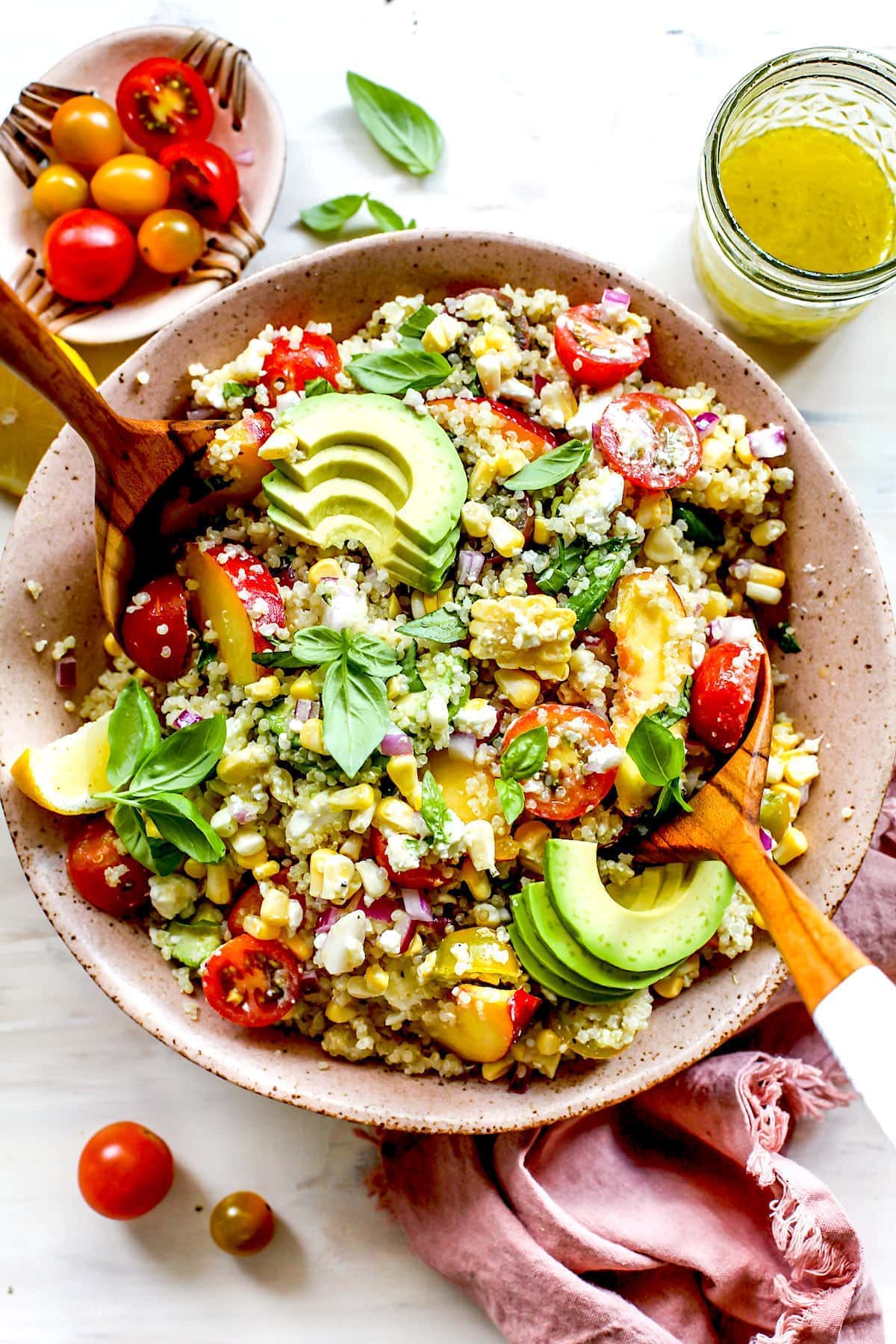 Summer Quinoa Salad in bowl with basil, avocado, tomatoes, corn, and ...