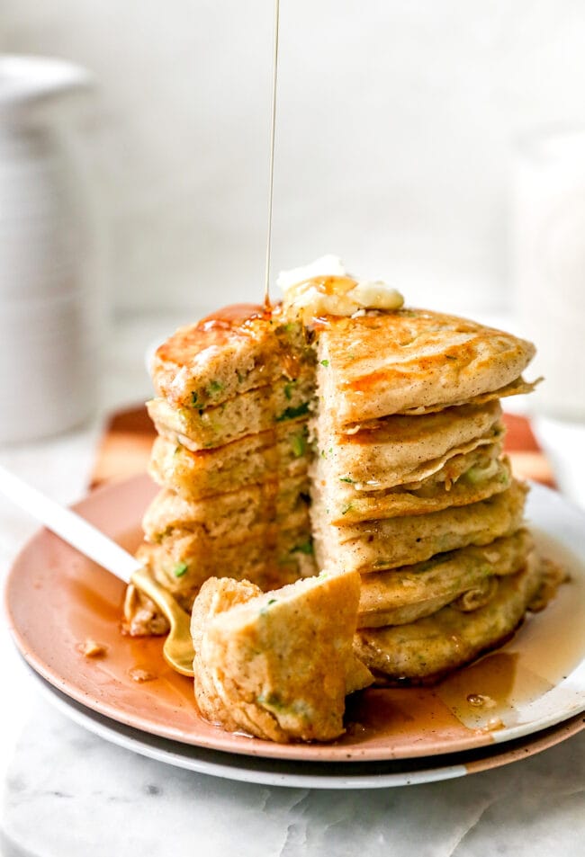 zucchini pancakes stacked and cut with maple syrup