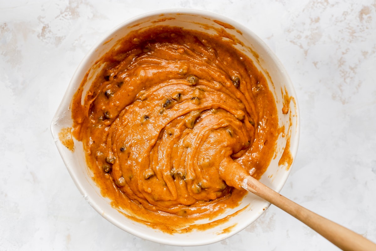 pumpkin chocolate chip bread batter in bowl with spatula. 