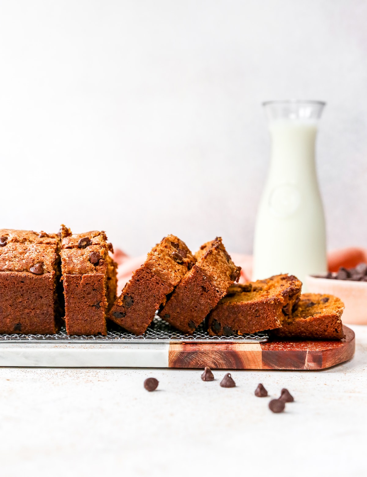 pumpkin chocolate chip bread cut in slices with bottle of milk.