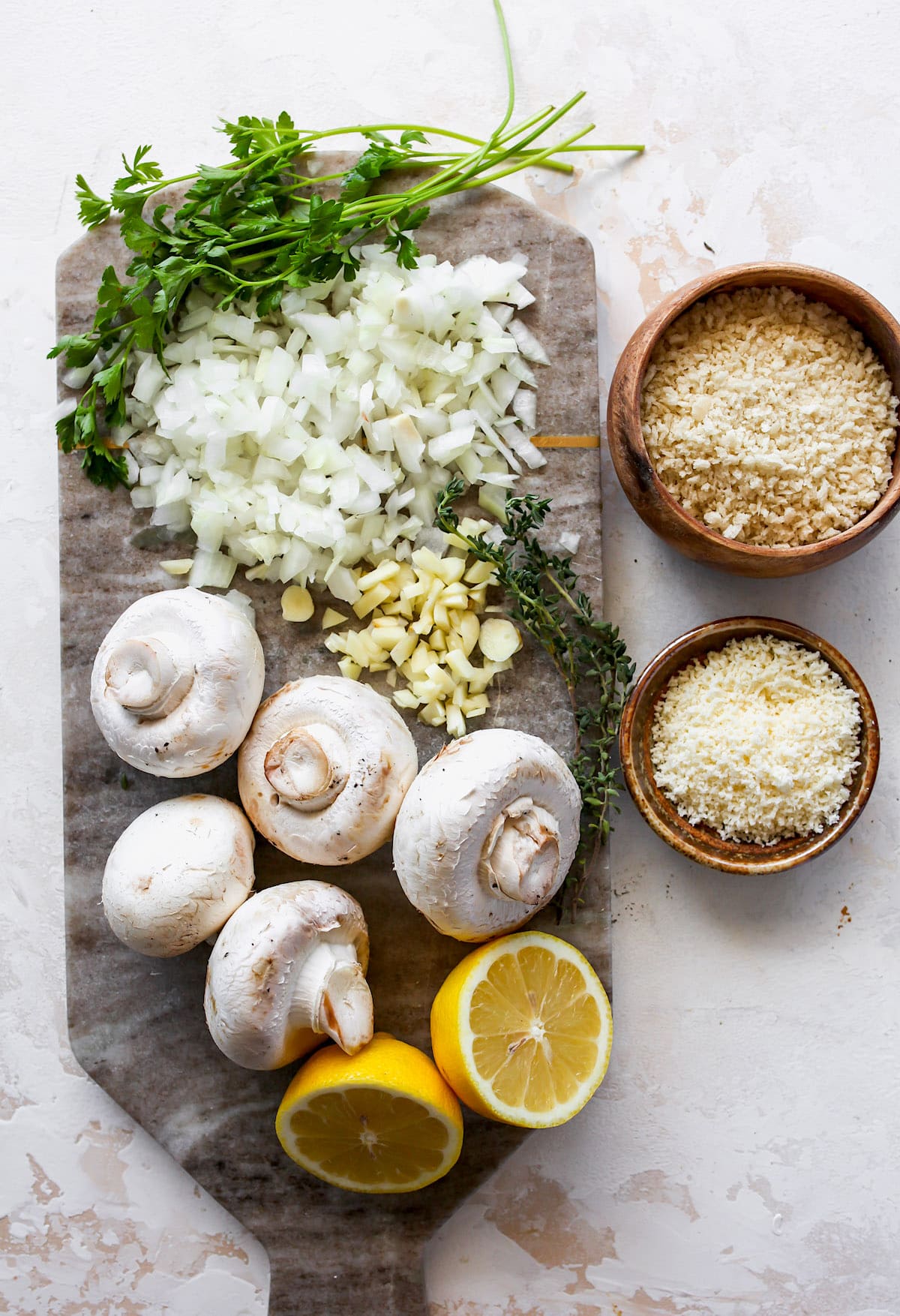 stuffed mushroom ingredients on marble tray and in bowls.