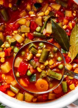 Close up of vegetable soup being ladled from a pot.