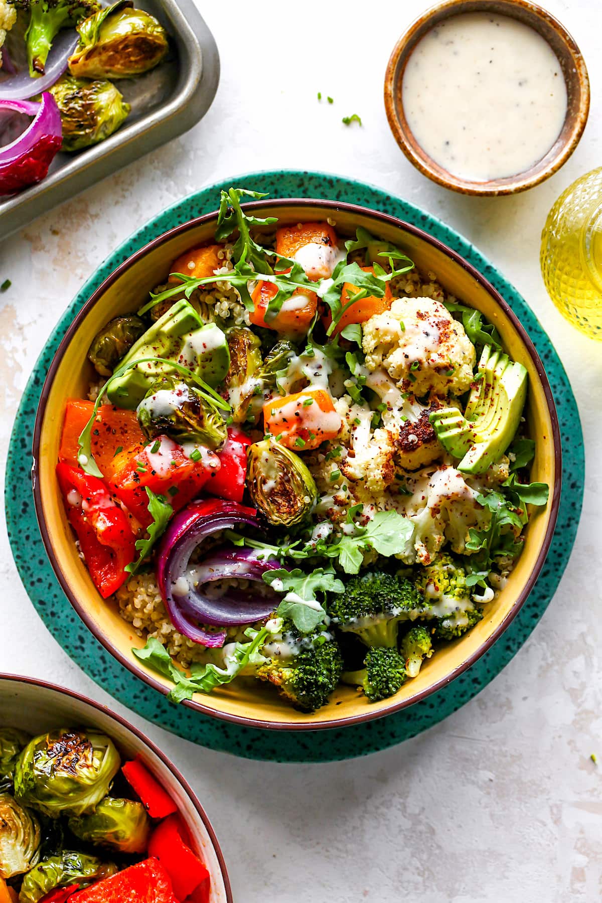 roasted vegetable bowl with quinoa, greens, avocado, and tahini dressing. 