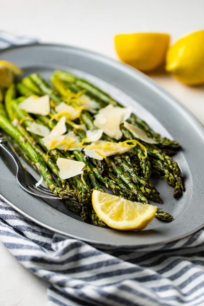 roasted asparagus recipe on platter with lemon and parmesan cheese
