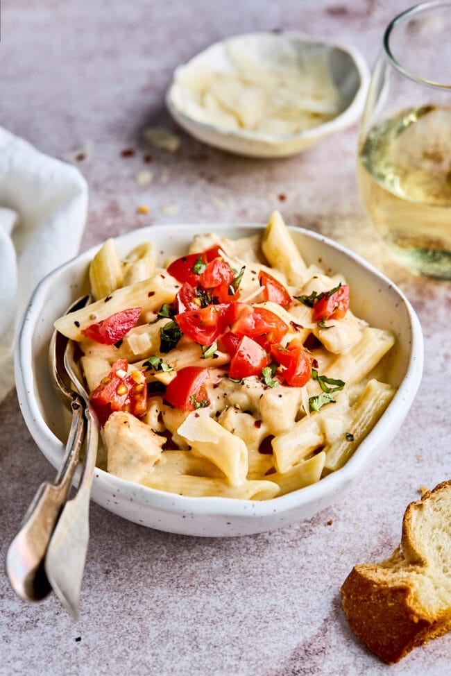 Foto Stock Pasta pene with chicken pieces mushrooms parmesan cheese sauce  and herb decoration. Pene con pollo - Italian or medierranean cuisine