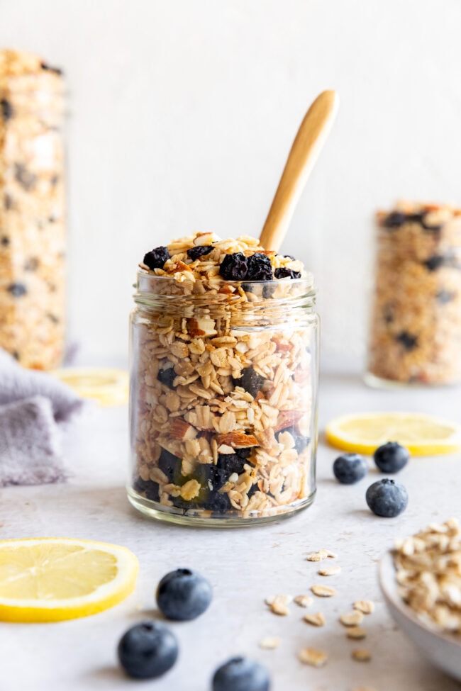 lemon blueberry granola in jar with wood spoon.