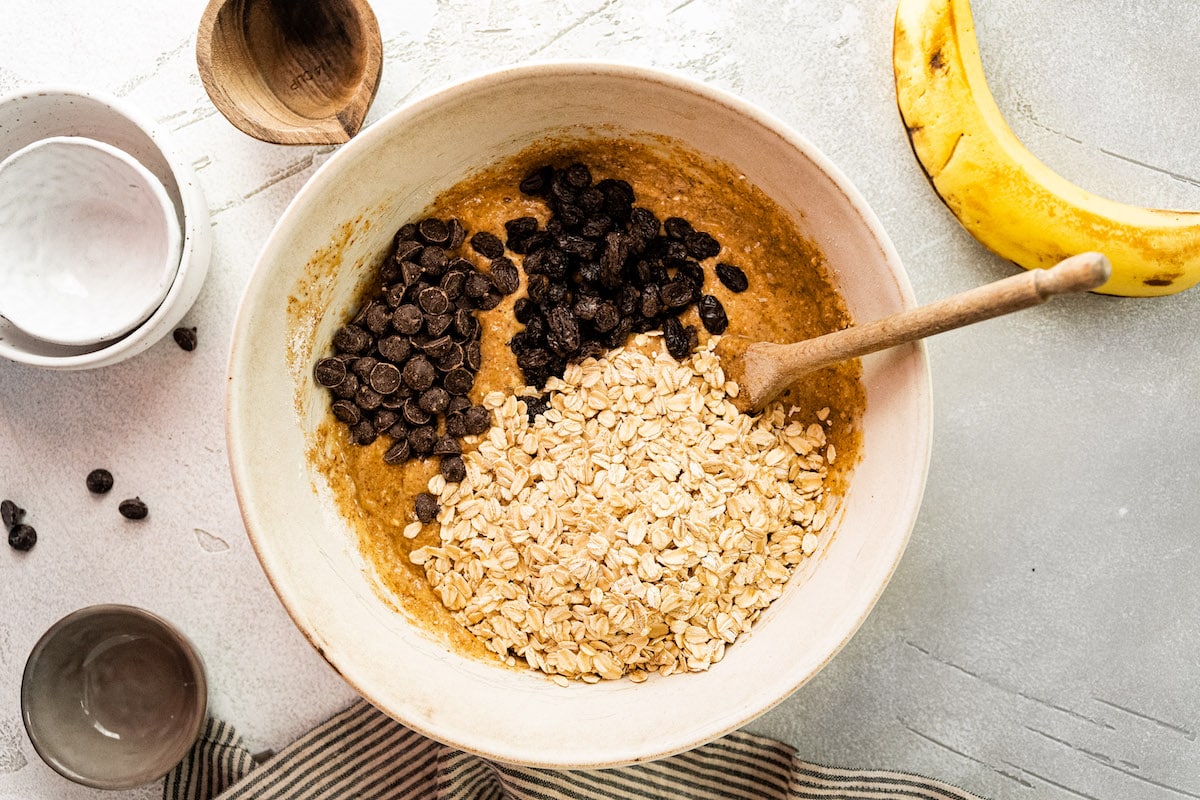 breakfast cookie ingredients in mixing bowl with wooden spoon. 