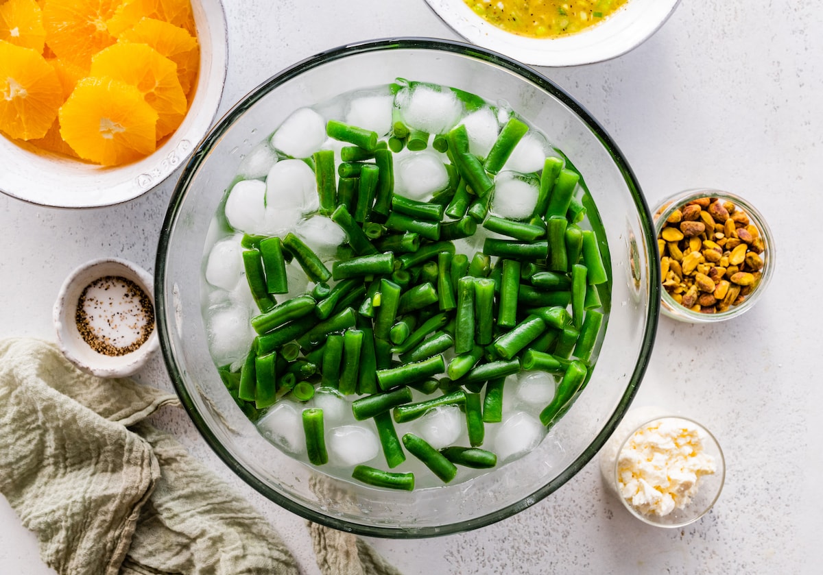 blanched green beans in bowl with ice. 