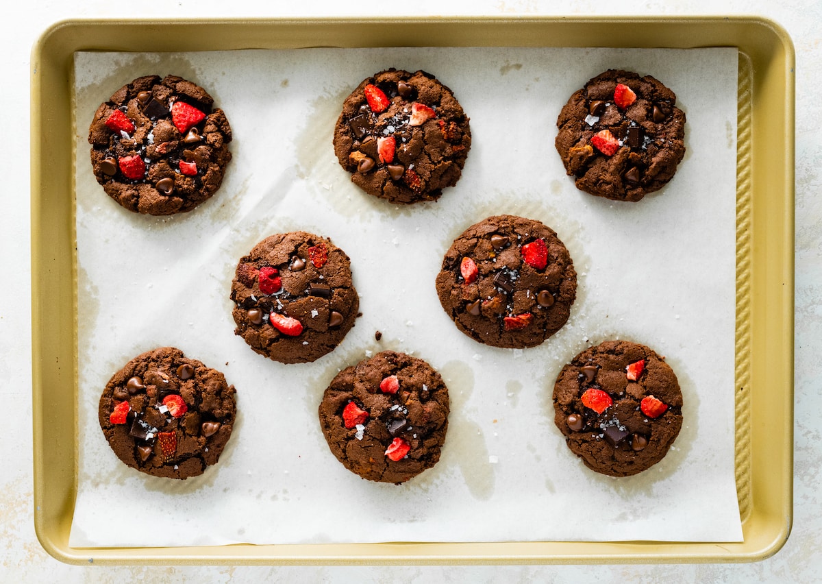 strawberry chocolate cookies cooling on baking sheet with parchment paper. 