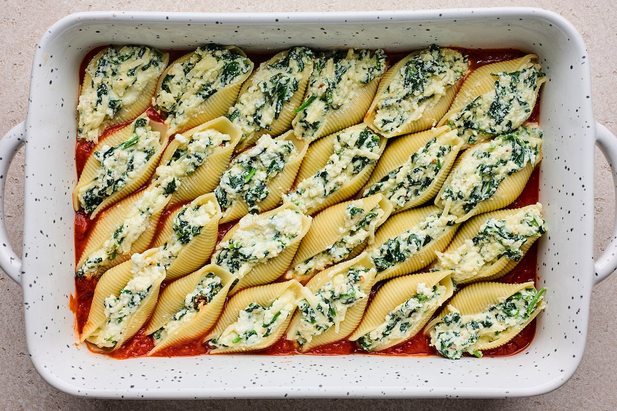 stuffed shells with ricotta spinach filling in baking dish. 