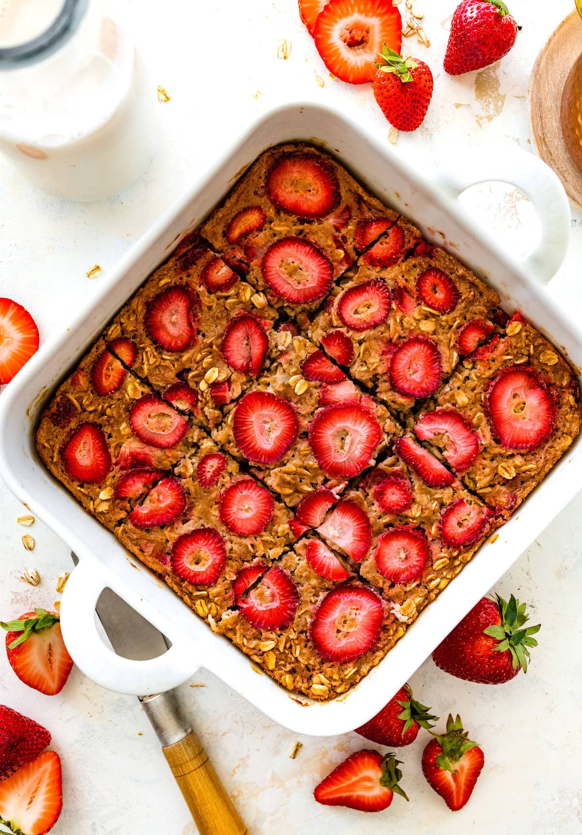 strawberry baked oatmeal cut into squares in baking dish. 