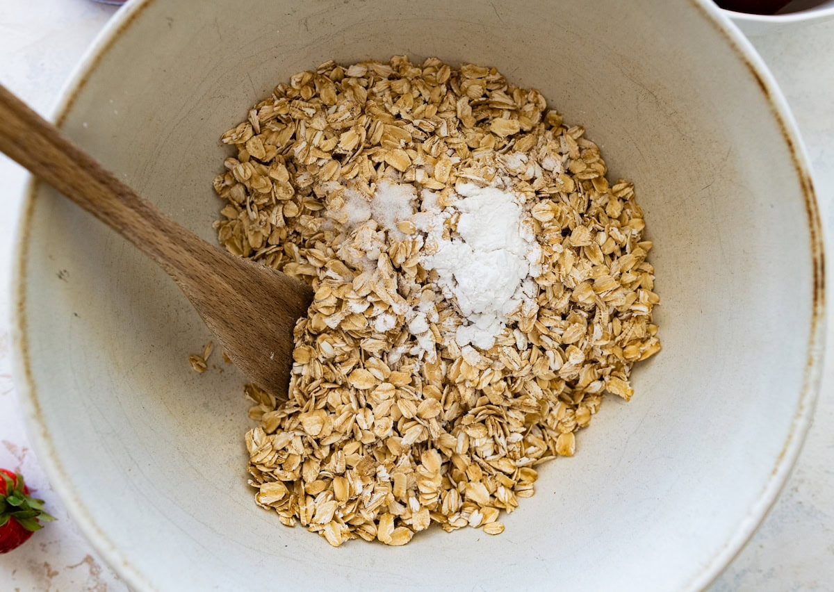 oats, baking powder, and salt in mixing bowl with wooden spoon. 