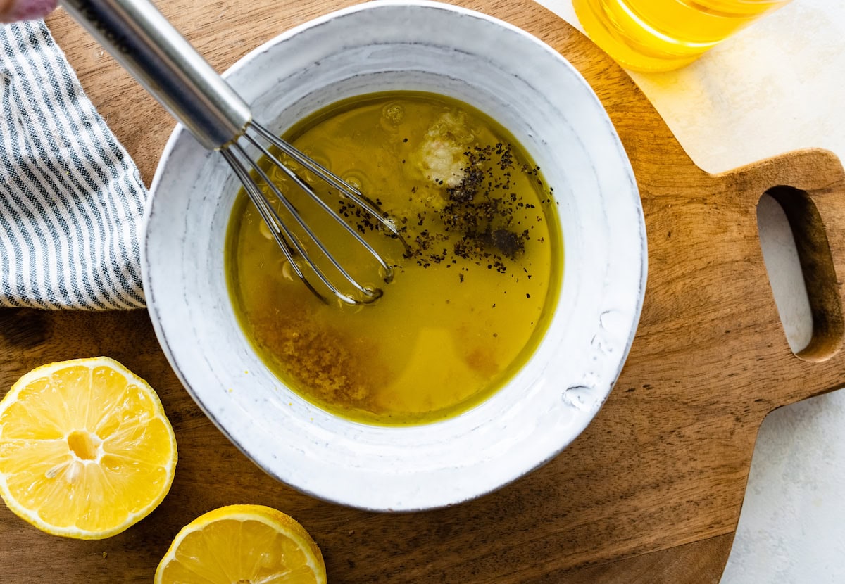 lemon dressing in bowl with whisk. 