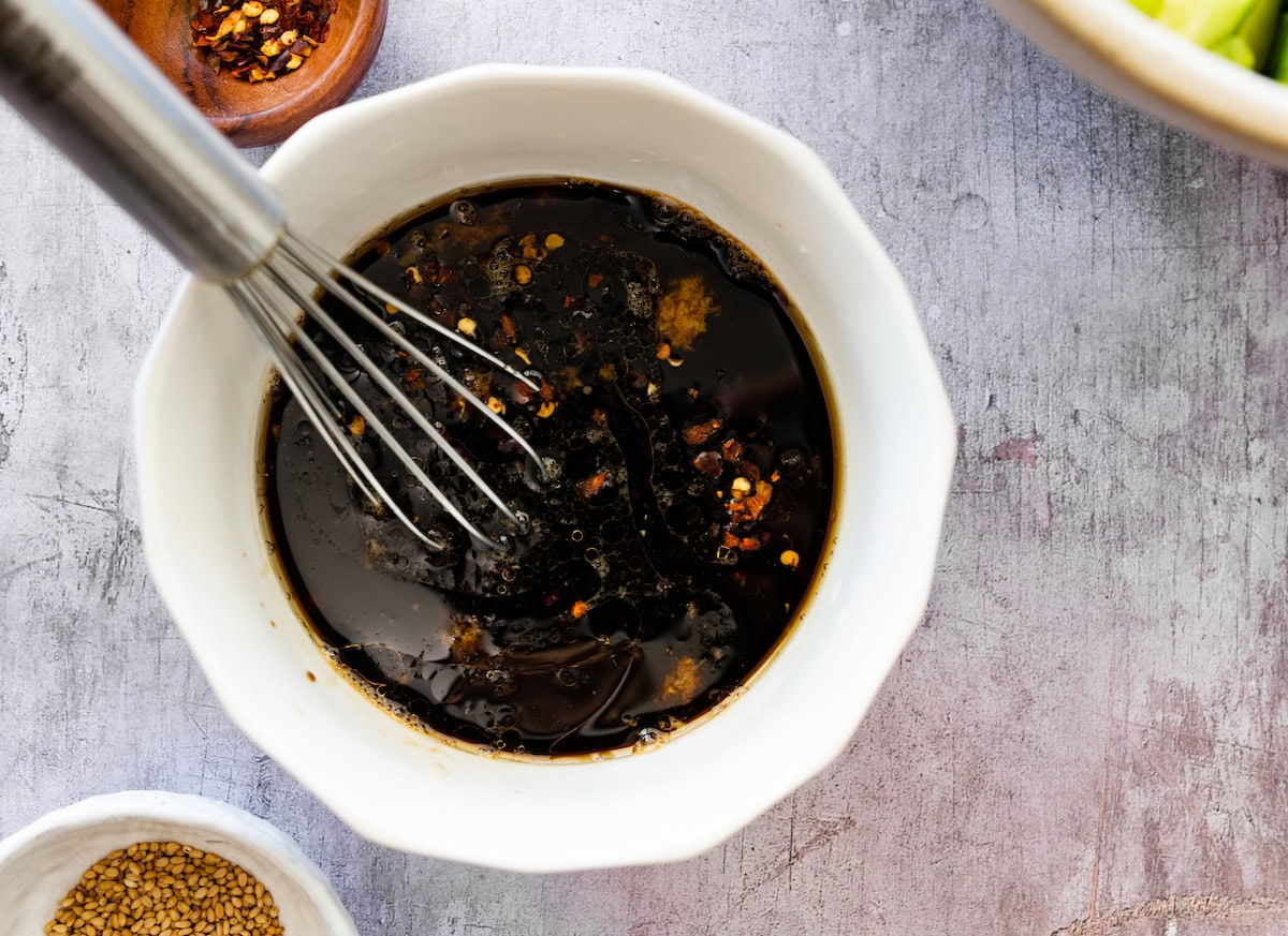 soy ginger dressing in bowl with whisk. 