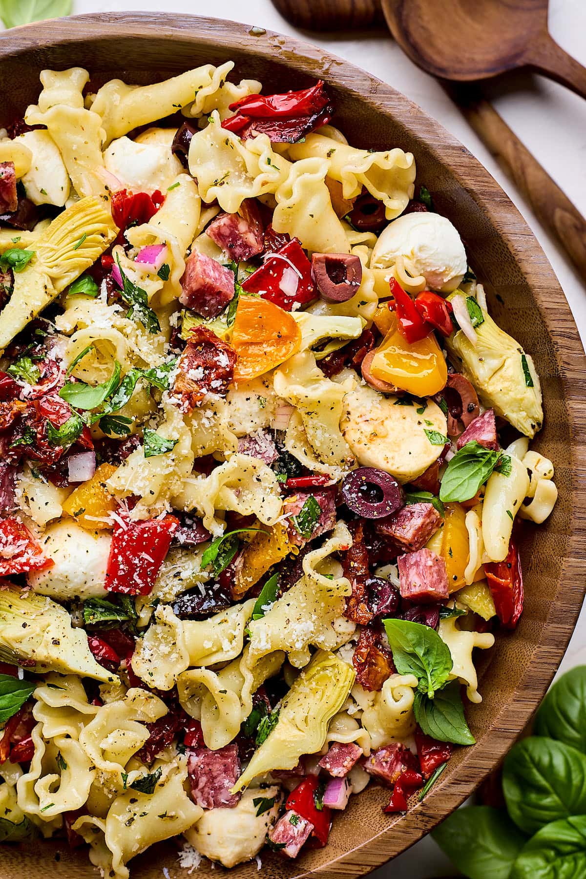 close up of Italian pasta salad in wood bowl. 