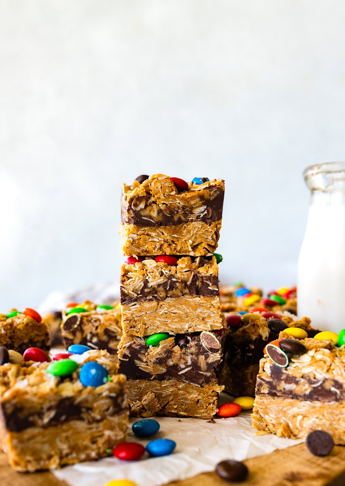 no bake monster cookie bars stacked with bottle of milk. 