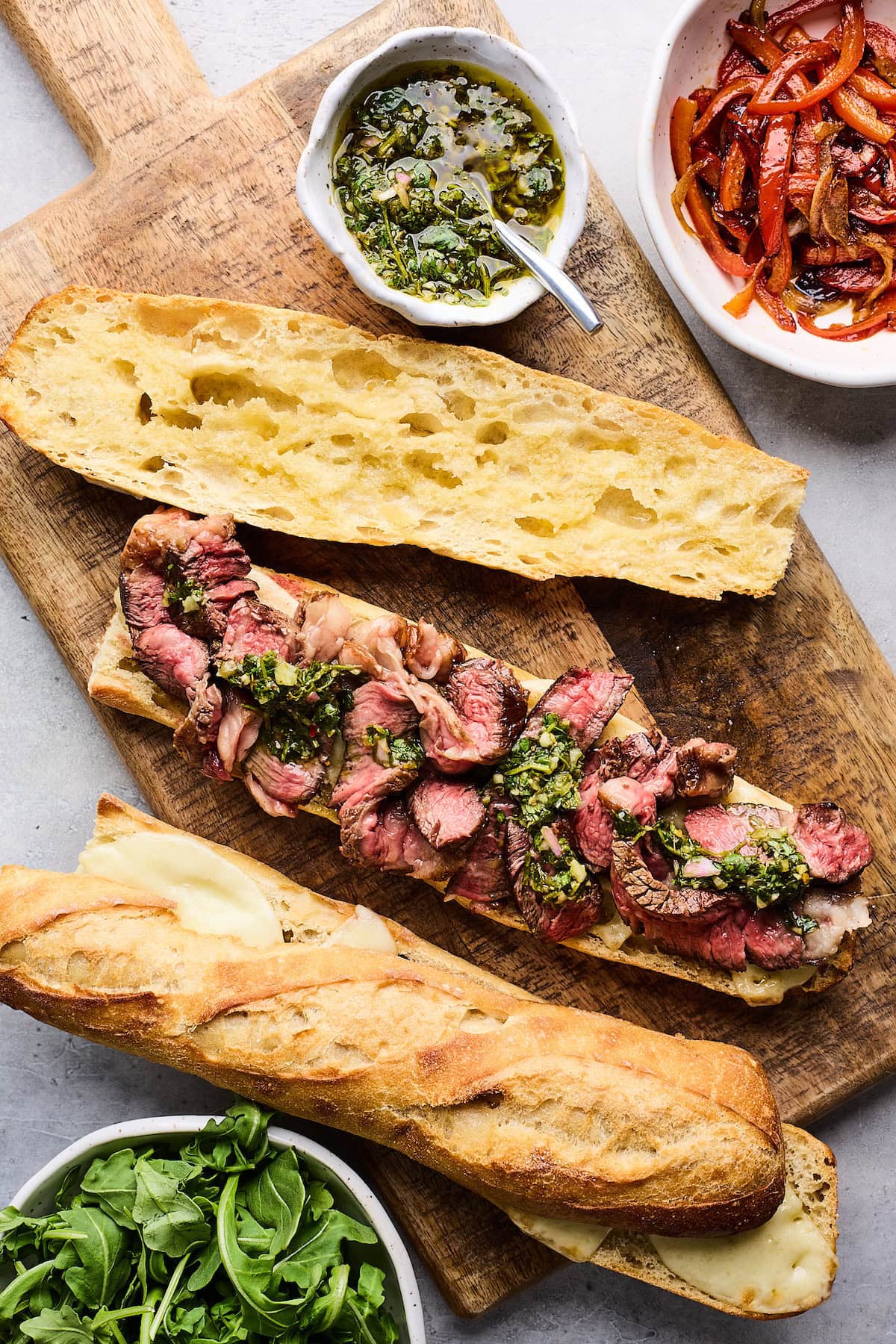steak sandwich with chimichurri on toasted baguette. 