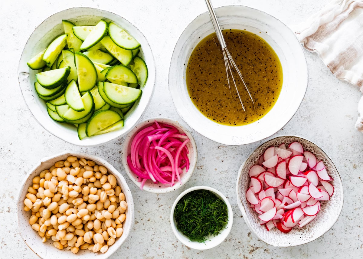 ingredients in bowls to make white bean cucumber salad. 