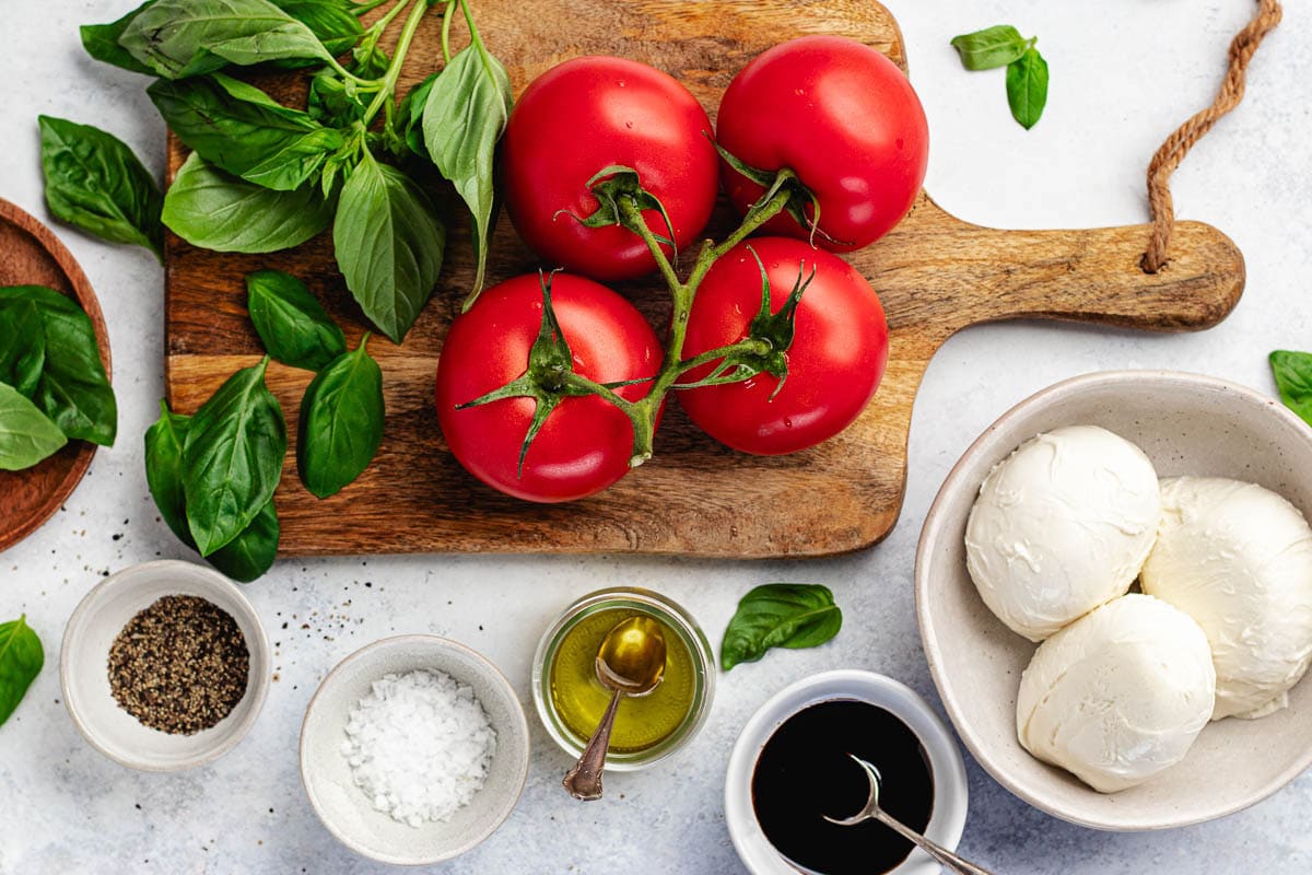 basil, tomatoes, fresh mozzarella cheese, balsamic vinegar, olive oil, salt and pepper to make caprese salad. 