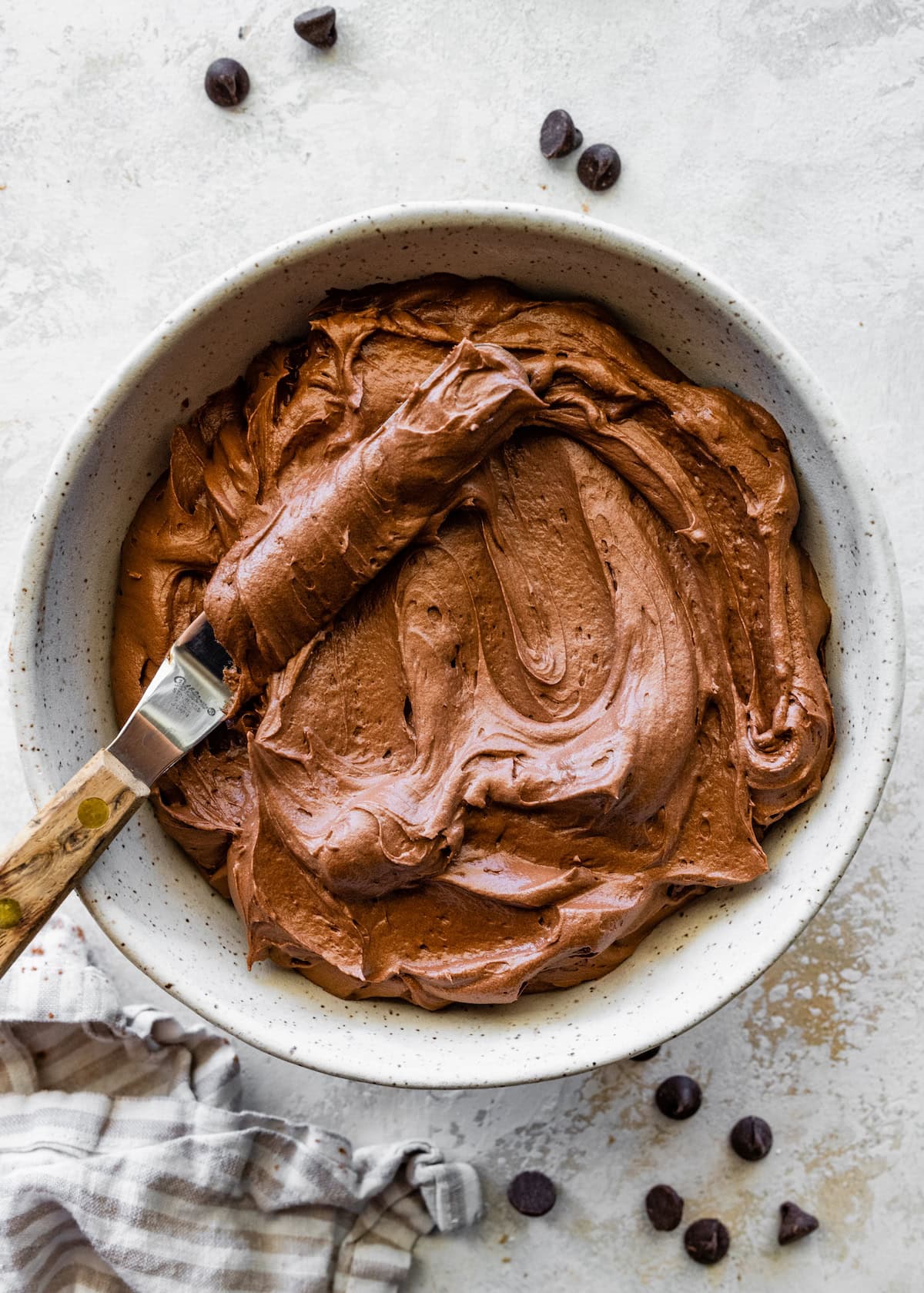 chocolate frosting in bowl with spreader. 