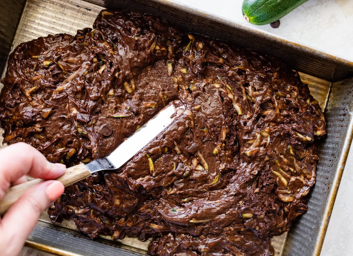 chocolate zucchini cake batter being spread in pan. 