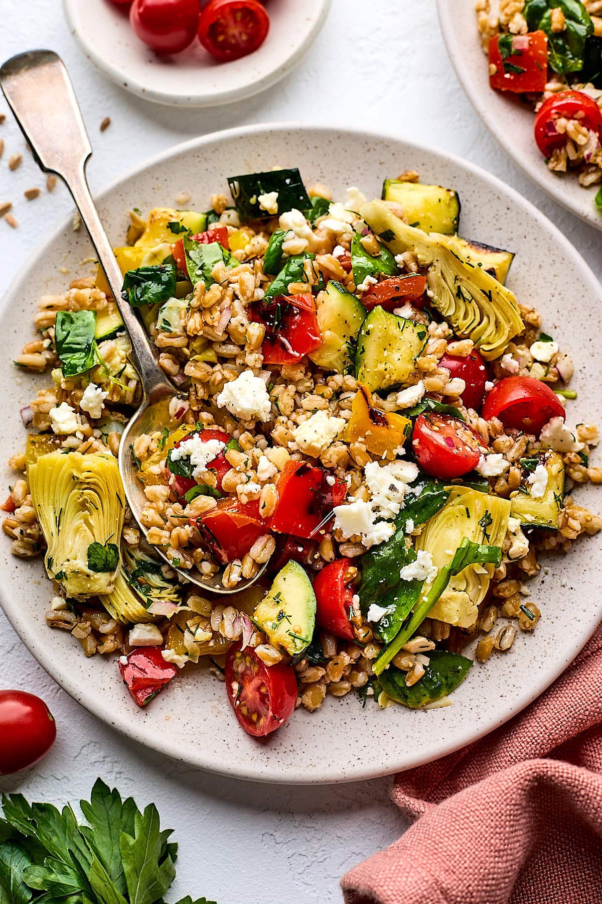 grilled vegetable farro salad on plate with serving spoon. 