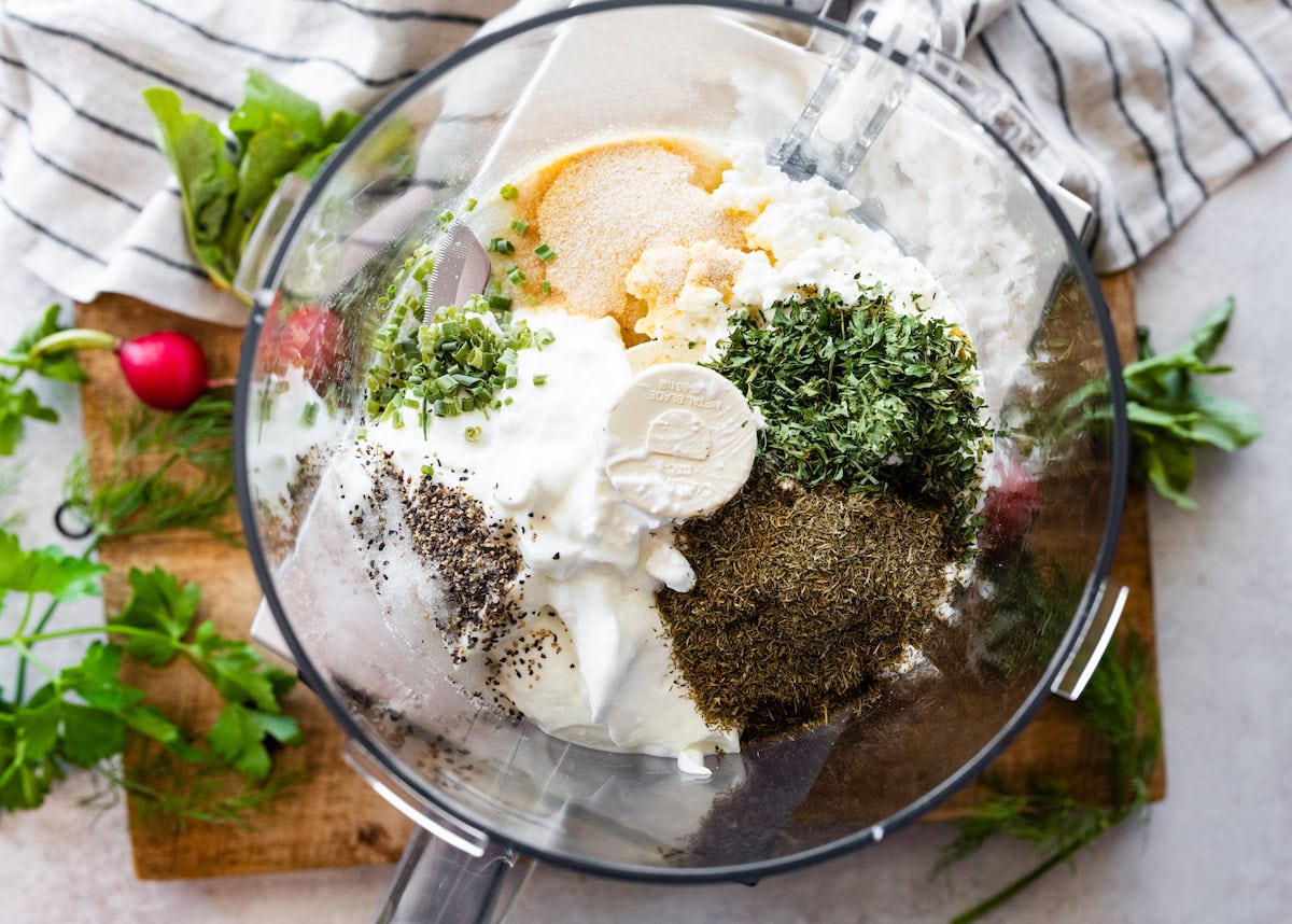 Greek yogurt, cottage cheese, lemon juice, herbs, and spices in food processor bowl to make ranch dip. 