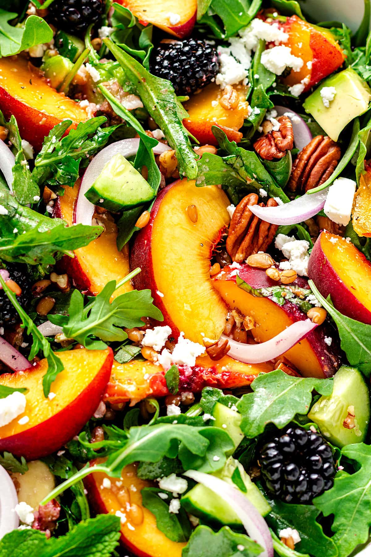 close up of blackberry peach arugula salad. 