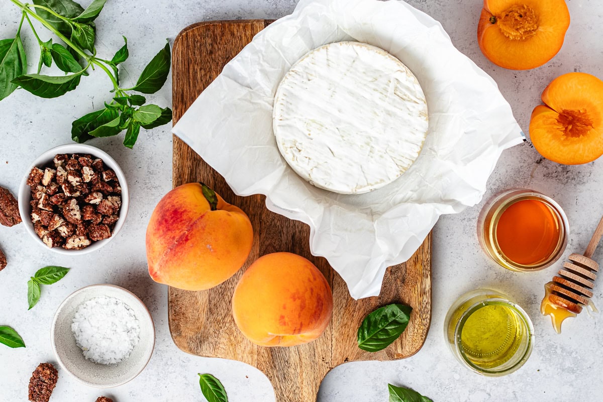 ingredients on wood board to make grilled brie with peaches. 