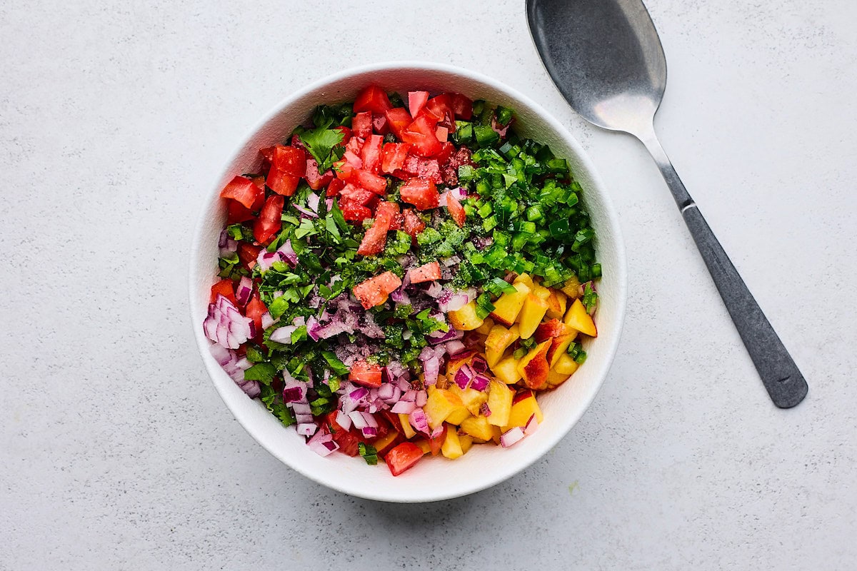 peach pico de gallo in bowl with spoon. 