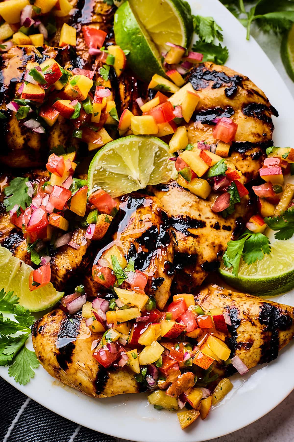 grilled hot honey chicken on platter with peach pico de gallo. 