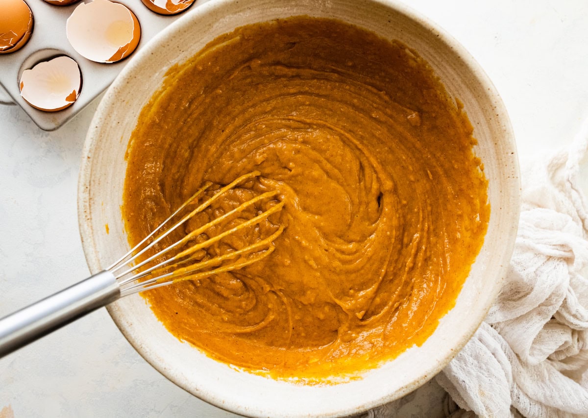 pumpkin cake batter with whisk in mixing bowl. 