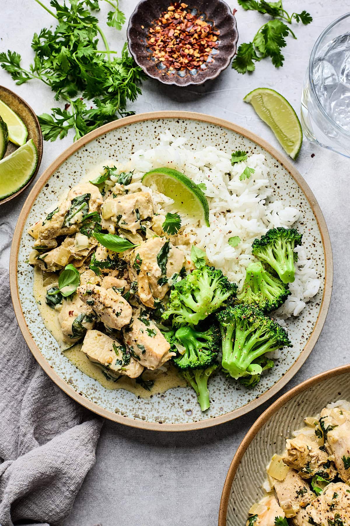 coconut lime chicken on plate with rice and broccoli with lime wedge. 