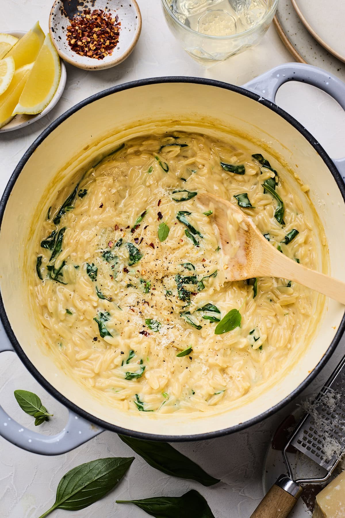 creamy orzo in pot with wooden spoon. 