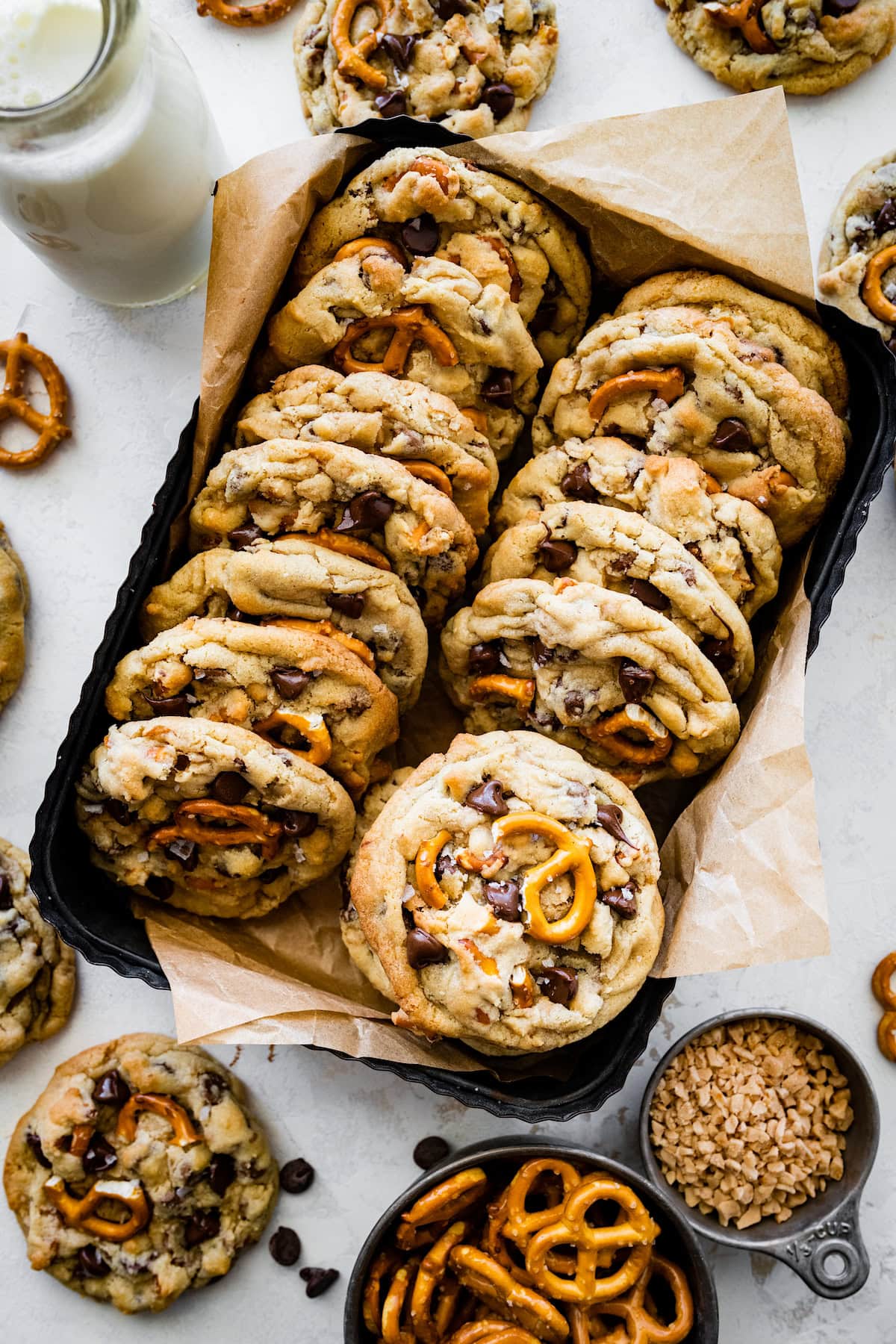 pretzel toffee chocolate chip cookies in container with parchment paper. 