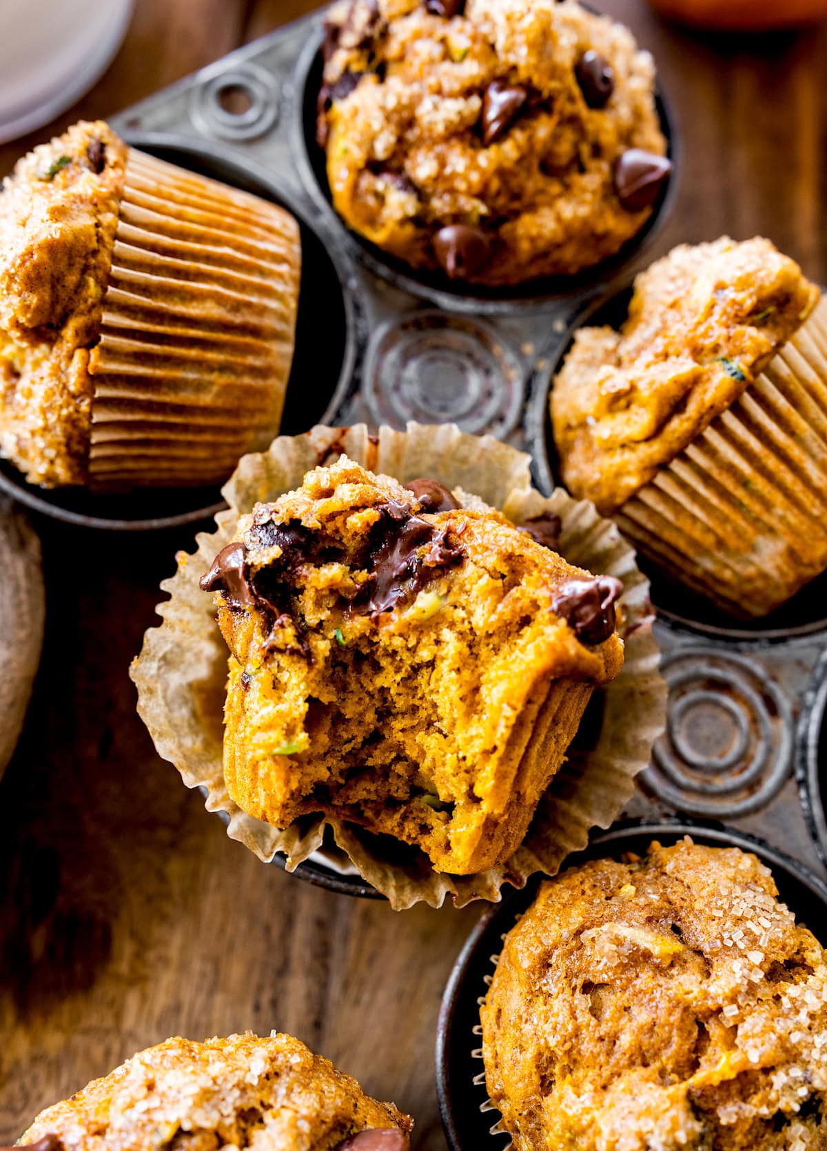 a bite out of a pumpkin zucchini muffin. 