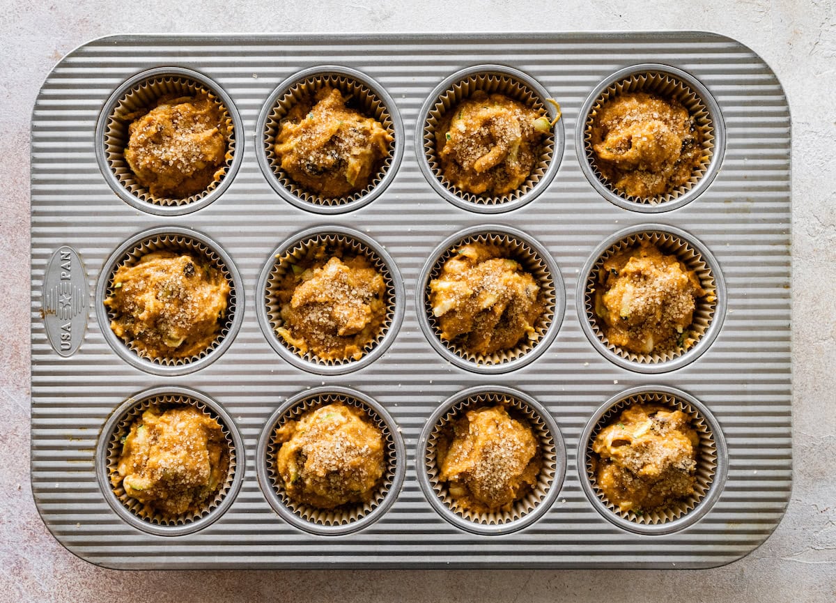 pumpkin zucchini muffin batter in muffin pan. 