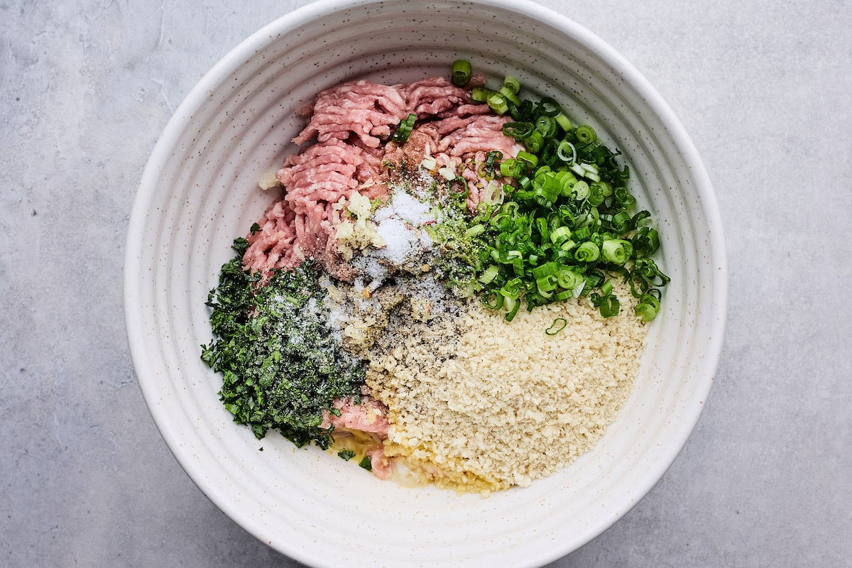 ground turkey, panko, egg, garlic, ginger, green onion, herbs in bowl to make soy ginger meatballs. 