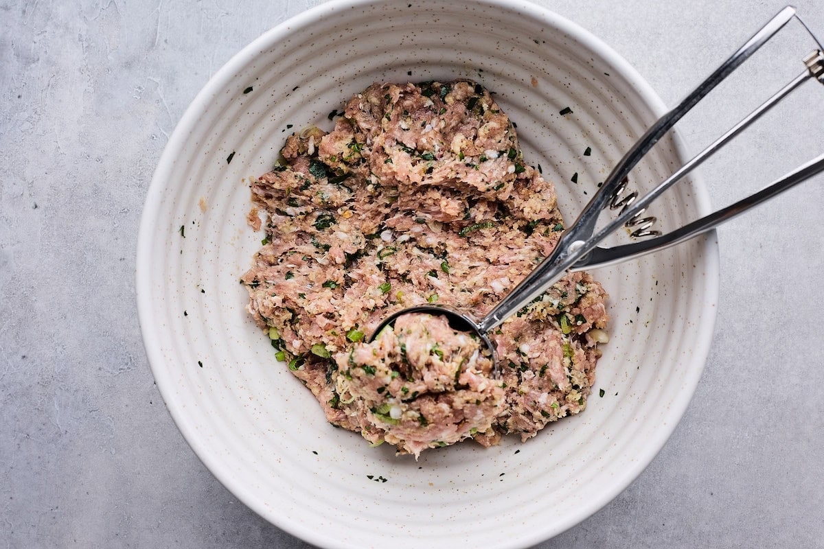 Asian-inspired soy ginger meatball mixture in mixing bowl with scoop. 