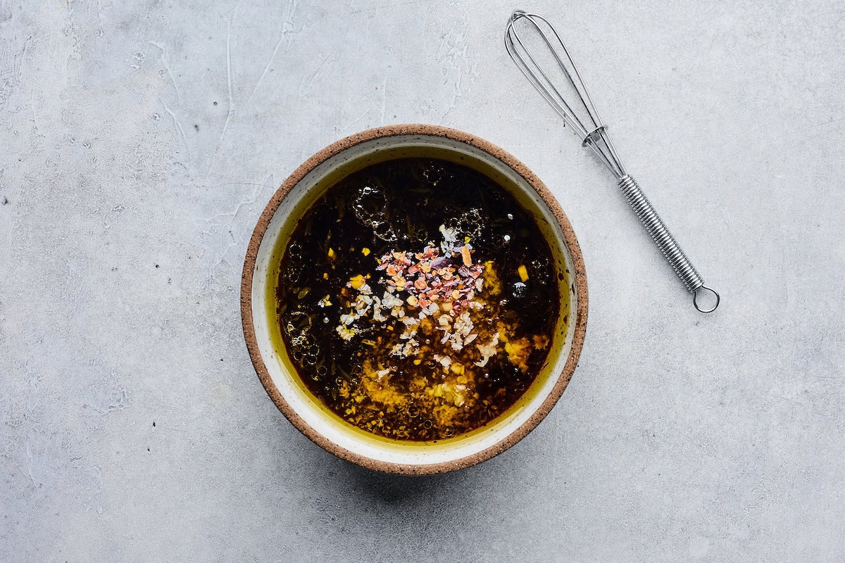 soy ginger dressing in bowl with whisk. 