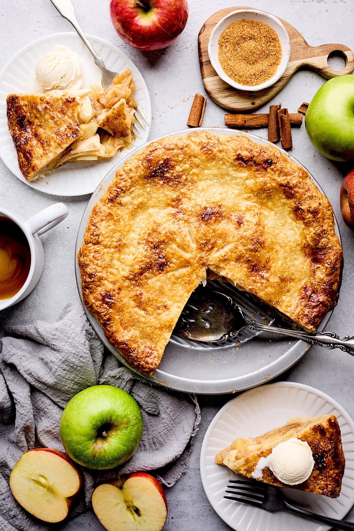 apple pie with 2 pieces of pie on plates with ice cream. 