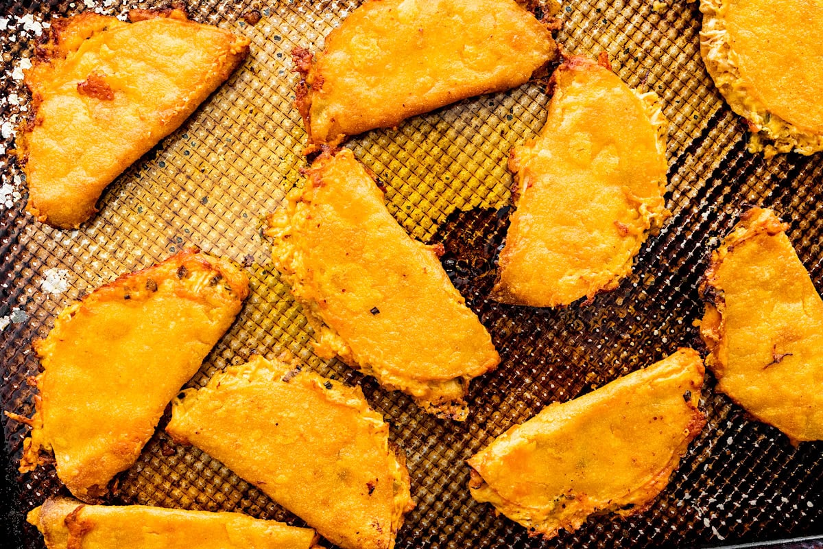 crispy buffalo chicken tacos on baking sheet. 