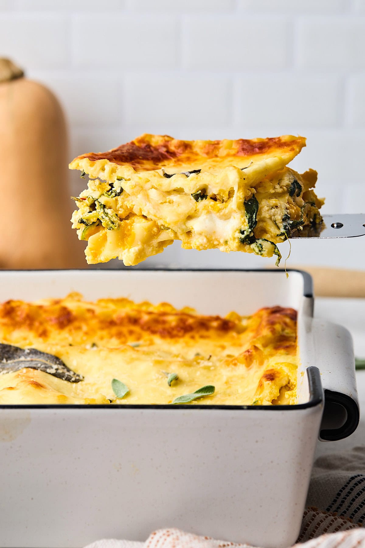 a piece of butternut squash being lifted out of the pan with a spatula. 