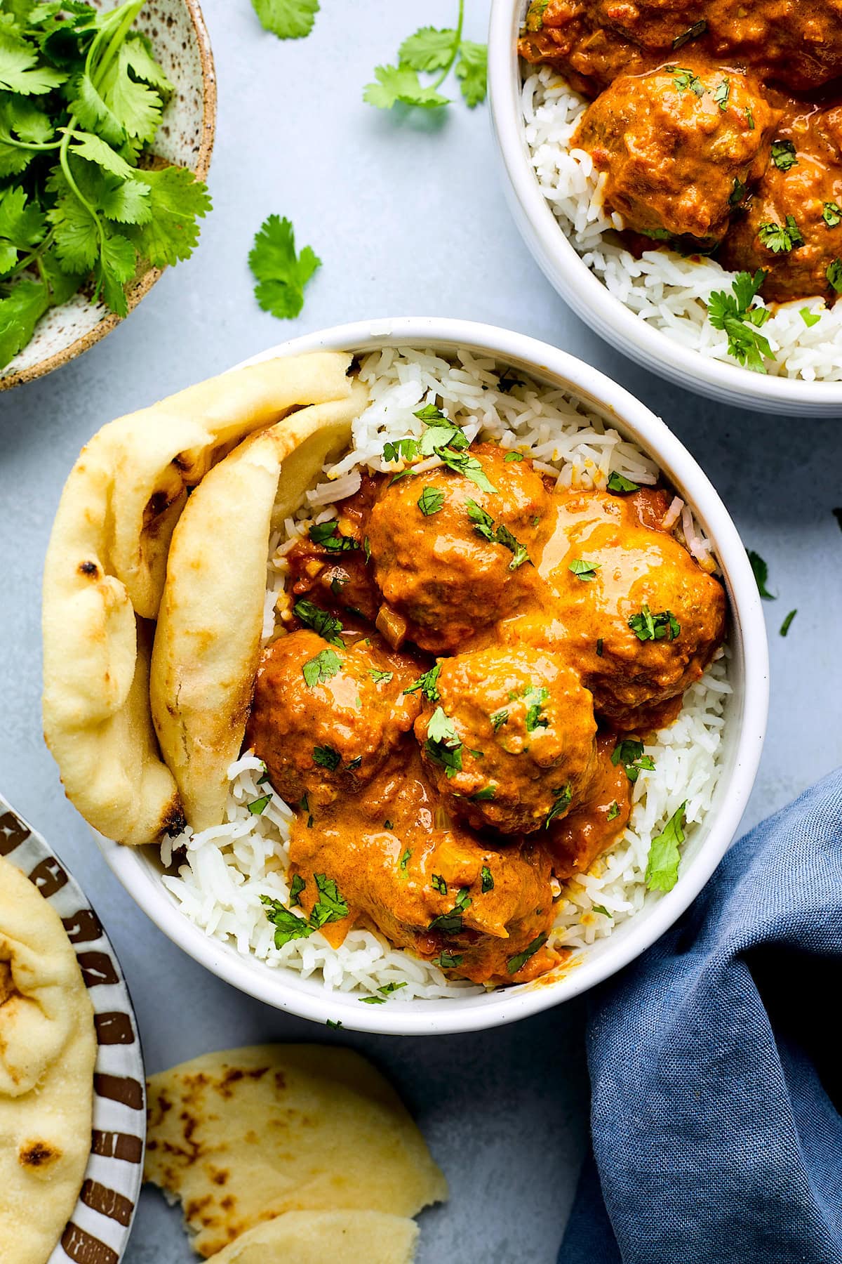 tikka masala meatballs in bowl with rice and naan bread. 