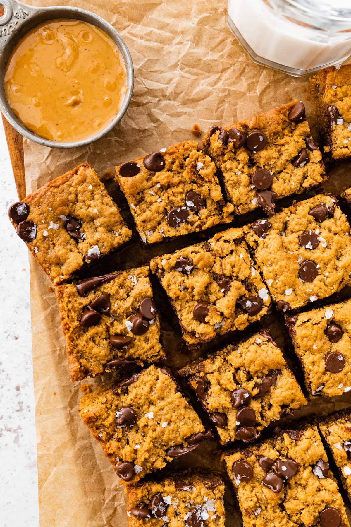 flourless peanut butter blondies with chocolate chips cut in squares with flaky sea salt. 