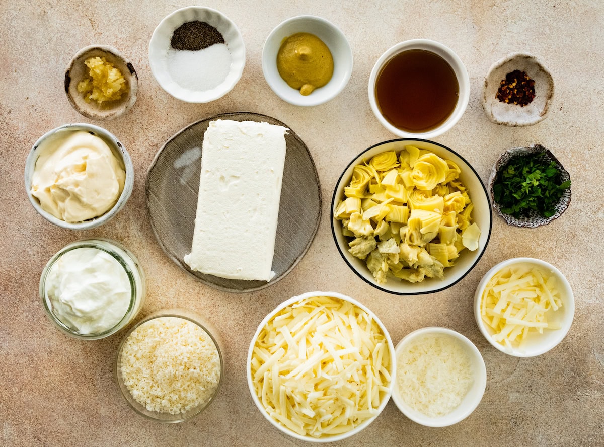 ingredients in bowls to make artichoke dip. 