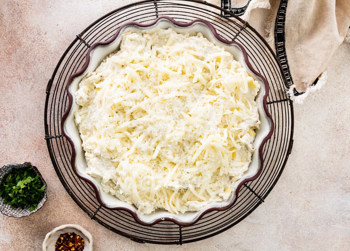 artichoke dip in baking dish with cheese on top. 