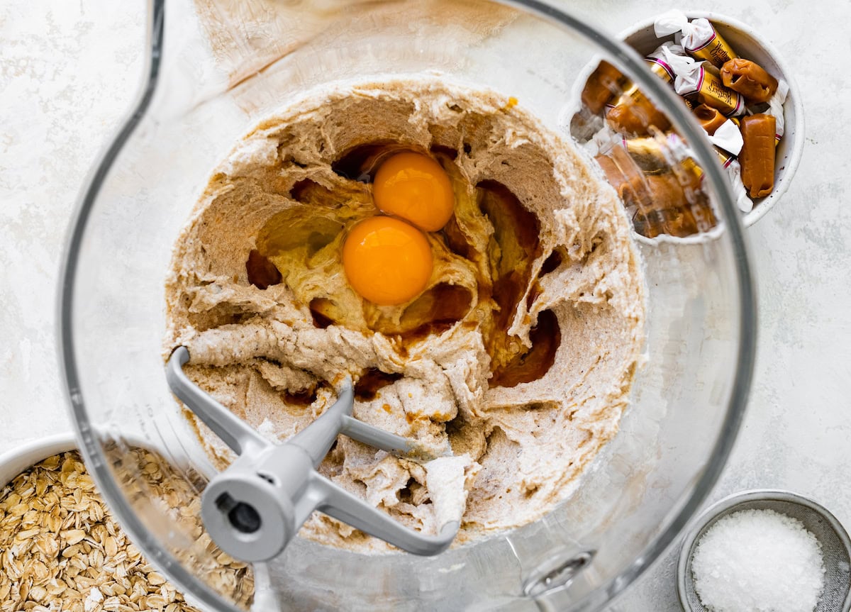 creaming butter and sugars together in mixing bowl and adding eggs and vanilla extract. 