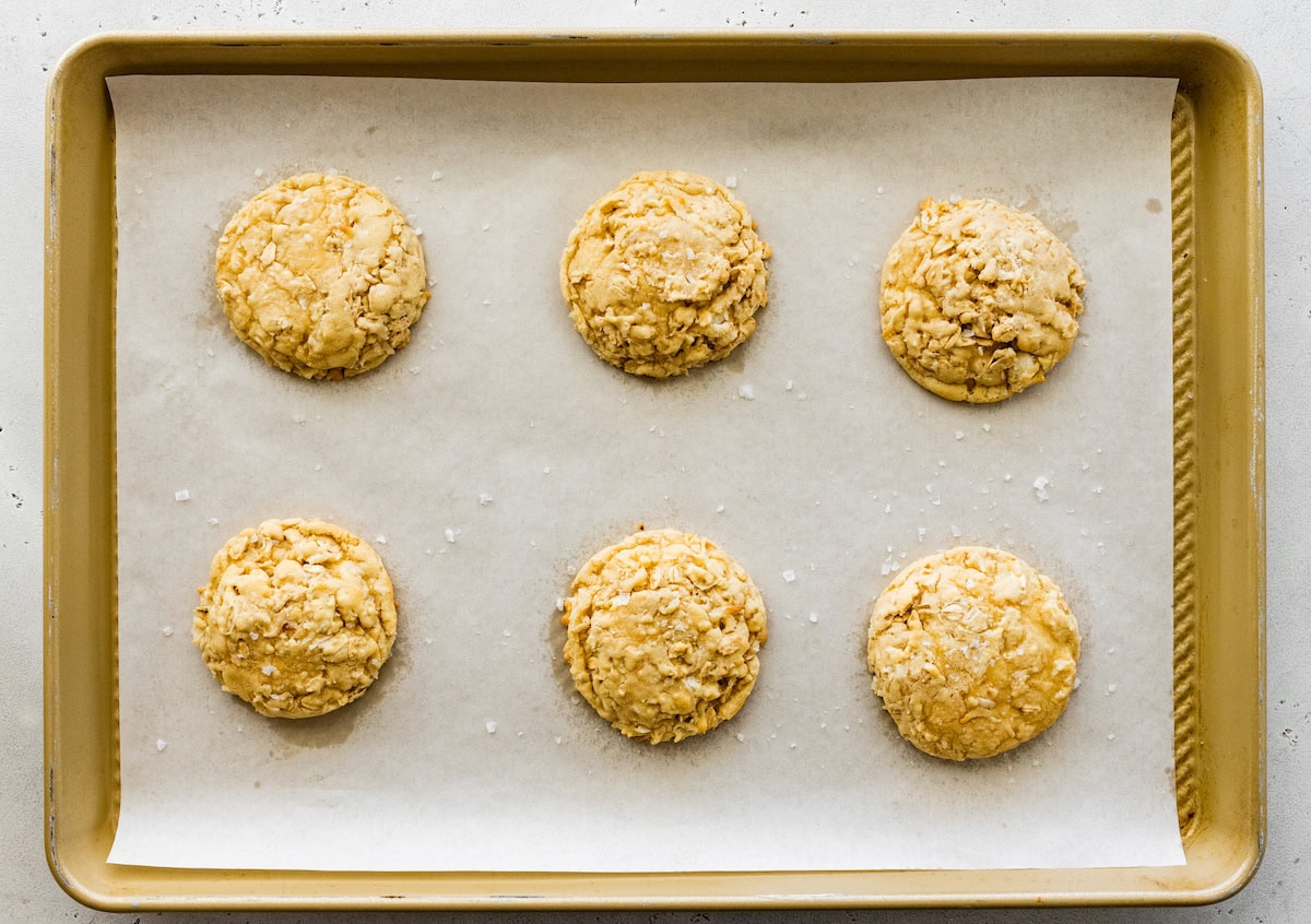 coconut cookies on baking sheet with parchment paper. 